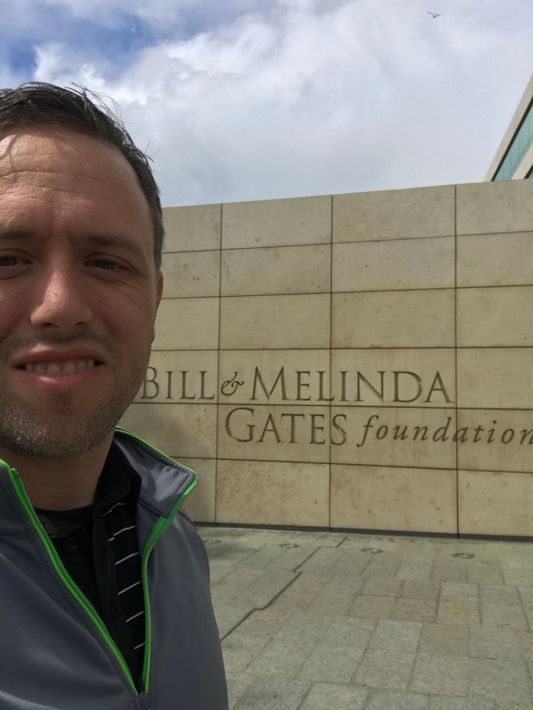 The author stands in front of the entrance to the bill and melinda gates foundation building in seattle.